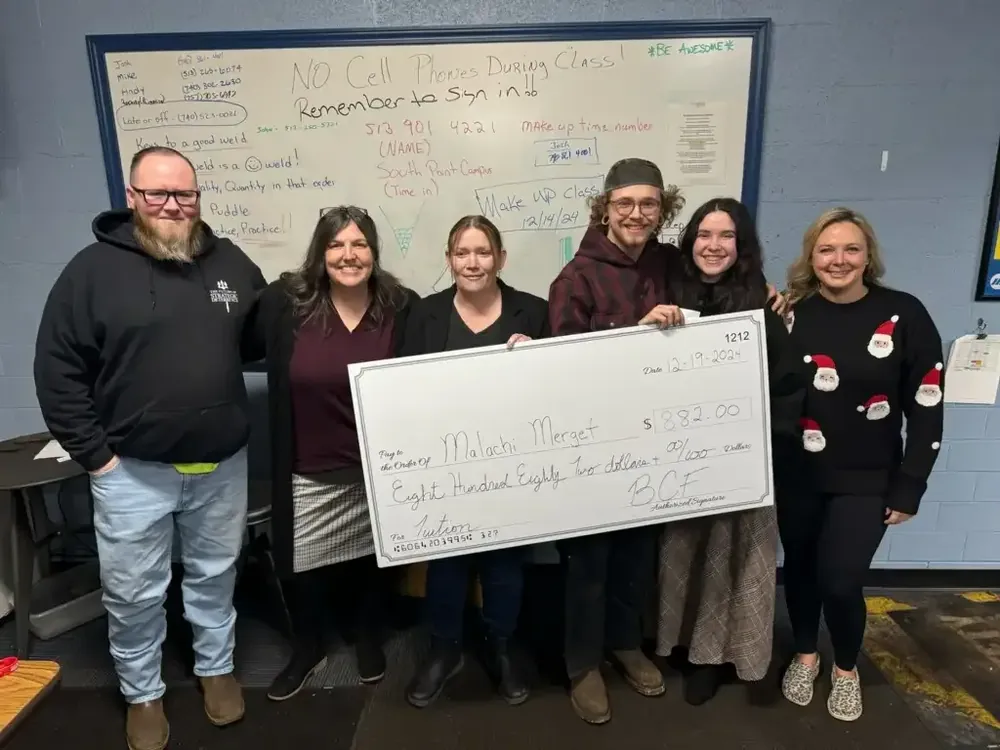 BCF staff and partners presenting an oversized grant check in the BCF office
