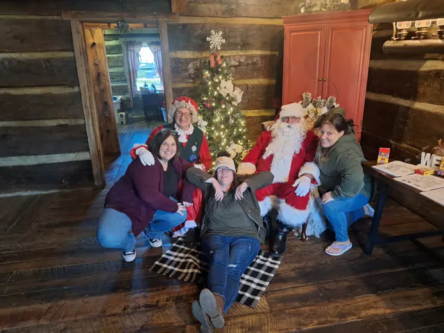 Families with Santa in front of the tree at the BCF cabin — Christmas 2025