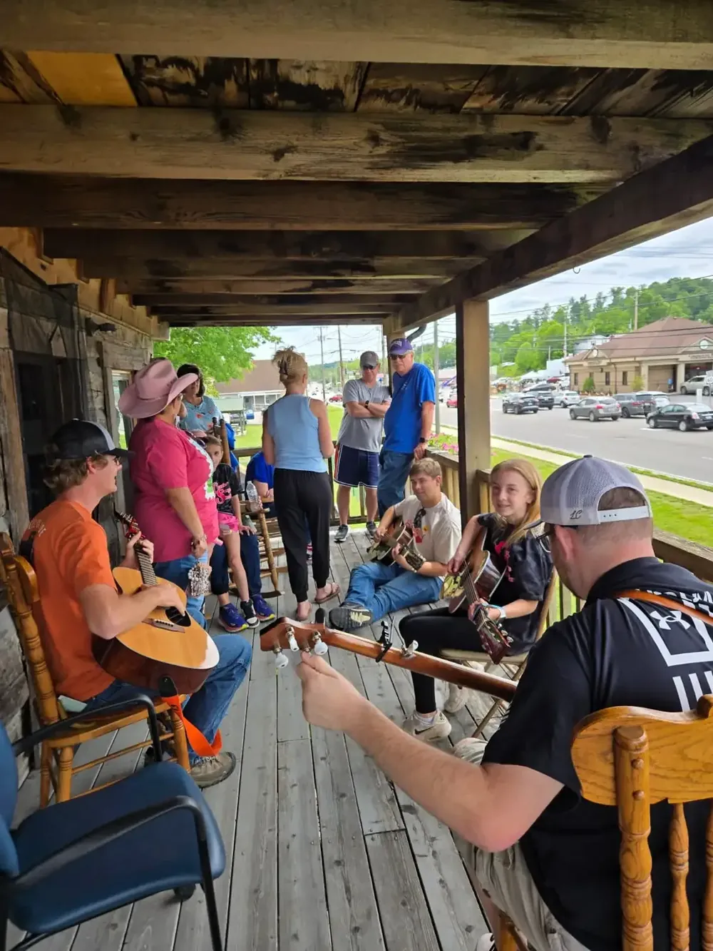 Musicians playing on the porch of the BCF cabin while neighbors listen